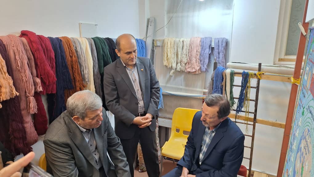 رییس سازمان بهزیستی کشور کنار دار قالی هنرمند ناشنوای گیلانی نشست